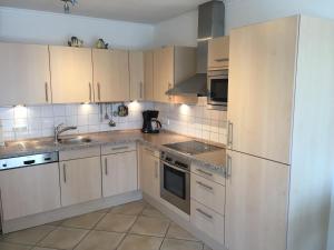 STR150b "Residenz Johannsens" F في نيندورف: مطبخ مع دواليب بيضاء واجهزة ستانلس ستيل +4 صور