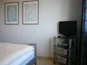 STR150b "Residenz Johannsens" F في نيندورف: غرفة نوم مع سرير وتلفزيون على منصة