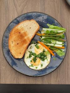 达累斯萨拉姆Ingoo Club的一个蓝色盘子里装着鸡蛋、吐司和蔬菜。