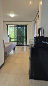 a room with a bed and a microwave on a refrigerator at Malaika Residence in Sampong