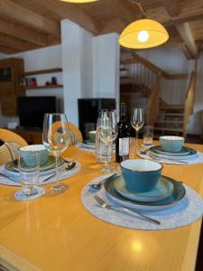 a table with plates and bowls and wine glasses at Ferienhaus Gollbichl in Sachrang +35 photos