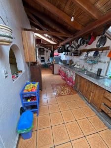 a kitchen with a counter and a tile floor at Pakarina Hospedaje in Cotacachi
