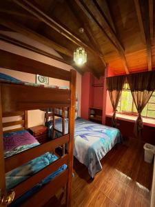 a bedroom with two bunk beds and a window at Pakarina Hospedaje in Cotacachi