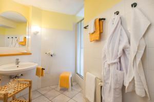 biała łazienka z umywalką i lustrem w obiekcie Hotel Das Gastein - ganzjährig inklusive Alpentherme Gastein & Sommersaison inklusive Gasteiner Bergbahnen w mieście Bad Hofgastein