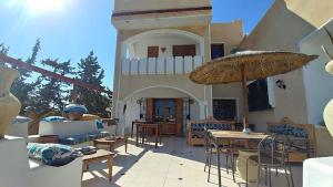 a patio with tables and chairs and a building at Darsawani in Triffa