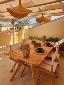 a wooden table with plates and bowls on it at Il giardino di Gaia in Portoferraio