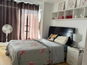 Casa Portada del Sol في La Molina: غرفة نوم مع سرير ومكتب مع مروحة