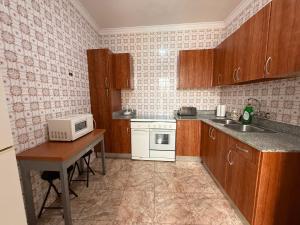 een kleine keuken met een tafel en een magnetron bij Rooms La Laja 3 in Las Palmas de Gran Canaria