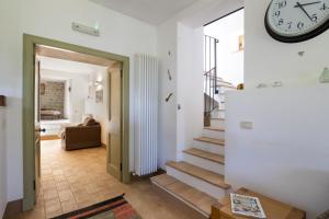 uma sala com um relógio na parede e escadas em CASALE LA CASCINA 8, Emma Villas em Force mais 22 fotografias