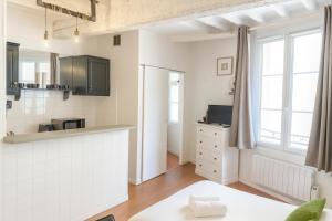 a kitchen with white cabinets and a counter top at Le Papassaudi by La Familia in Aix-en-Provence