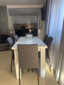 a white dining room table with chairs and a kitchen at Sophia Maria Caciulata in Caciulata +10 photos