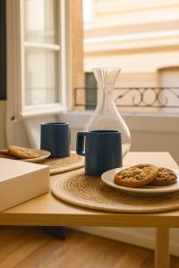 a table with a plate of cookies and a vase at Le Papassaudi by La Familia in Aix-en-Provence +20 photos