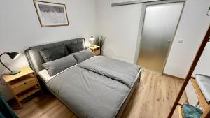 een slaapkamer met een bed en een nachtkastje met een lamp bij Wohlfühlwohnung mit Dachterrasse in Donaueschingen