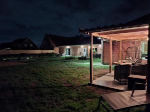 a backyard at night with a table and a pavilion at B&B De Scheldeberg in Zwevegem