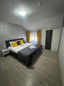 a bedroom with a large bed with yellow pillows at Casa Sophia Maria Caciulata in Caciulata