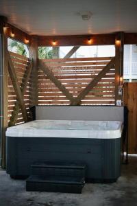 a large bath tub in a room with a wooden wall at Walk to everything, 360 views, elevator, fence in Surf City