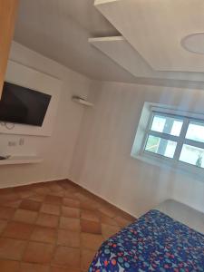 洛斯桑托斯Casa Cañón ecolodge的一间带床、电视和窗户的卧室