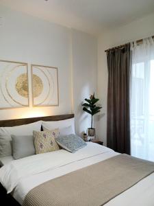 a bedroom with a large white bed with a window at Luxury Spot Xanthi in Xanthi