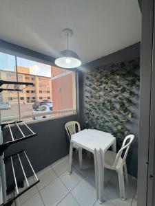 een tafel en stoelen in een kamer met een muur van wijnflessen bij Apt Eldorado perto da praia confortável para 2 a 5 pessoas in São Luís