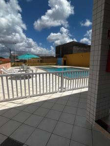 een zwembad op een gebouw met een wit hek bij Apt Eldorado perto da praia confortável para 2 a 5 pessoas in São Luís