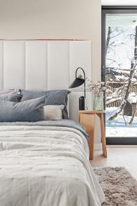 a bedroom with a bed and a lamp and a window at Njord in Tromsø