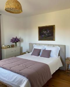 una camera da letto con un grande letto bianco con cuscini viola di Mystic Twistic a Vîrfurile Altre 68 foto