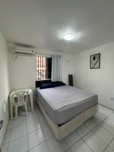 een slaapkamer met een bed en een tafel erin bij Apt Eldorado perto da praia confortável para 2 a 5 pessoas in São Luís +32 foto's