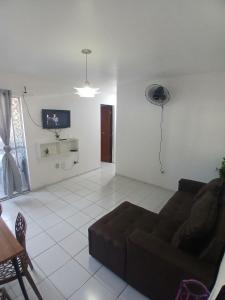 een woonkamer met een bank en een tv bij Apt Eldorado perto da praia confortável para 2 a 5 pessoas in São Luís