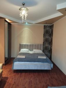a bedroom with a bed and a chandelier at Airport Apartments in Rīga