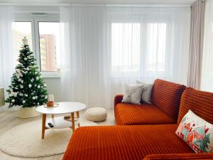 een woonkamer met een kerstboom en een bank bij A2 Severna Apartment, near City Center and High Tatras in Poprad
