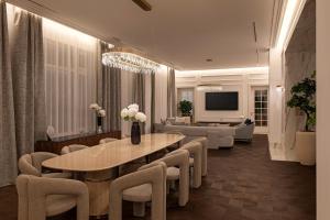 un salon avec une table, des chaises et un canapé dans l'établissement Avalon Luxury Villa, à Miskolc