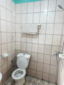 Un baño con un inodoro y una toalla en la pared. en Badenk Hôtel, en Yaoundé