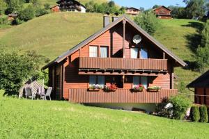 a wooden house with a balcony on a hill at Triberga Verwall in Sankt Gallenkirch