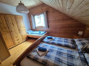 a bedroom with two beds in a wooden cabin at Triberga Verwall in Sankt Gallenkirch