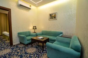 فندق جوهرة المقام الحمراء في جدة: غرفة انتظار مع أرائك زرقاء وطاولة وطاولة +93 صورة