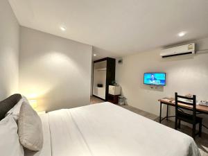 una camera da letto con un letto, una scrivania e una televisione di Studio F Sukhumvit a Bangkok Altre 34 foto