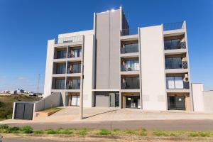 een wit appartementencomplex met een blauwe lucht bij Studio completo, Piscina, Wi-Fi e Garagem in Três Corações