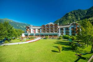 duży hotel z dużym trawnikiem przed nim w obiekcie Hotel Das Gastein - ganzjährig inklusive Alpentherme Gastein & Sommersaison inklusive Gasteiner Bergbahnen w mieście Bad Hofgastein