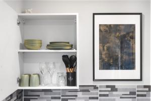 a kitchen with a shelf with dishes and a picture at Comfy Room and Parking Fast Access to Central London in Perivale +7 photos