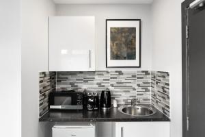 a kitchen with a sink and a microwave at Comfy Room and Parking Fast Access to Central London in Perivale