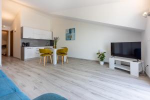 ein Wohnzimmer mit einem Tisch und gelben Stühlen in der Unterkunft Apartments Sunshine E in Crikvenica