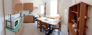 a kitchen with a table and a kitchen with a microwave at Villa Angelica in Capilungo