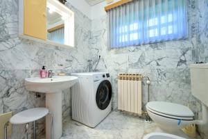 a bathroom with a washing machine and a sink at Villa Requiem in Bednja +51 photos