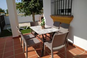 a wooden table and chairs on a patio at Chalet Chaparrillo Conil Rentals in Conil de la Frontera