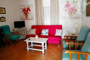 a living room with a red couch and chairs at Chalet Chaparrillo Conil Rentals in Conil de la Frontera