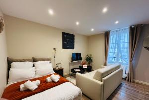 a bedroom with a large bed and a chair at Le Studio, parking & accès Plage ! in Trouville-sur-Mer