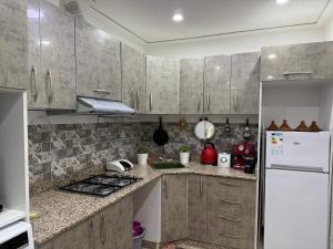 una cucina con mobili in legno e un frigorifero bianco di Sweet and Simple a Oujda Altre 15 foto