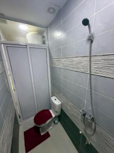 bagno con doccia e servizi igienici con sedile rosso di Sweet and Simple a Oujda