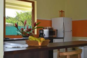 a kitchen with a counter top with a bowl of bananas at Maison confortable avec piscine à Goyave in Goyave