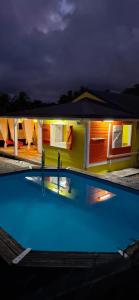 Maison confortable avec piscine à Goyave في Barbier: مسبح امام بيت بالليل